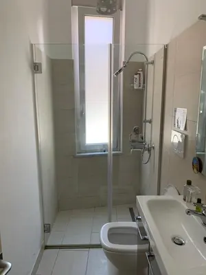 a bathroom with a shower and a toilet and a sink at Due Cani Apartment in Palermo