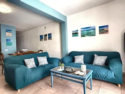 a living room with a blue couch and a table at Casa Alamar 100 metri dal mare in Alcamo