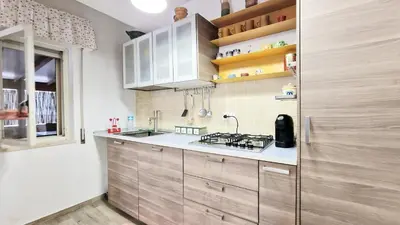 a kitchen with white cabinets and a sink and a stove at Casa Alamar 100 metri dal mare in Alcamo