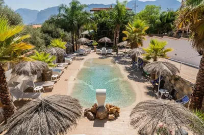an outdoor swimming pool with umbrellas and chairs and a resort at RhelizeOne & Spa جميل in Palermo