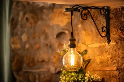 a light bulb hanging from a stone wall at RhelizeOne & Spa جميل in Palermo