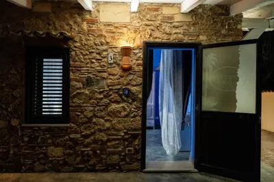 a stone wall with a door and a window at RhelizeOne & Spa جميل in Palermo