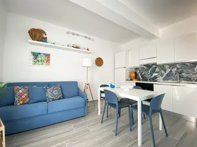 a living room with a blue couch and a table at A Cantunera in San Vito lo Capo