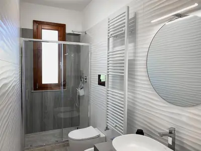 a bathroom with a toilet and a sink and a mirror at A Cantunera in San Vito lo Capo