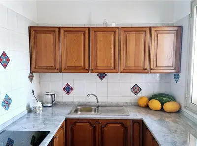 a kitchen with wooden cabinets and a sink and melons on the counter at casaafauka in Carini