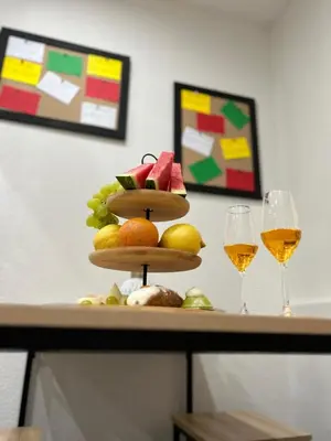 a table with two glasses of wine and a fruit tower at Casa Elivì Ballaró 2 passi dal centro storico, parcheggio e stazione ferroviaria in Palermo