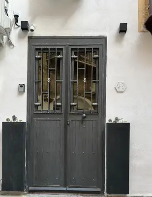 a black door on a building with a window at Casa Elivì Ballaró 2 passi dal centro storico, parcheggio e stazione ferroviaria in Palermo