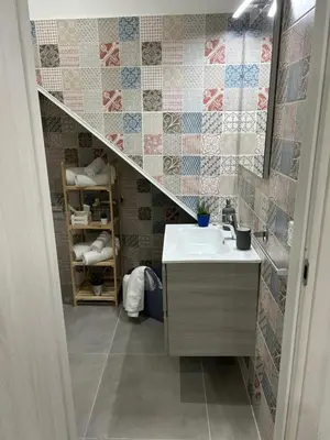 a bathroom with a sink and a mirror and a staircase at Casa Elivì Ballaró 2 passi dal centro storico, parcheggio e stazione ferroviaria in Palermo