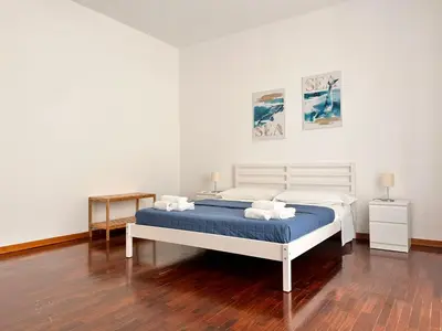 a bedroom with a bed with blue and white sheets at Casavacanze nel blu Maestrale in Isola delle Femmine