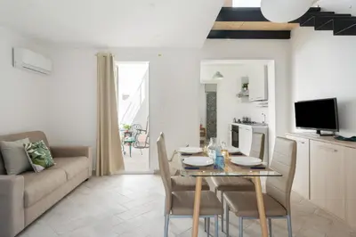 a kitchen and living room with a table and chairs at RYS Mondello House in Palermo