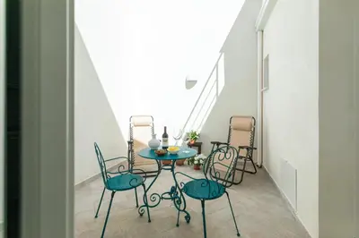 a table and chairs in a room with a staircase at RYS Mondello House in Palermo