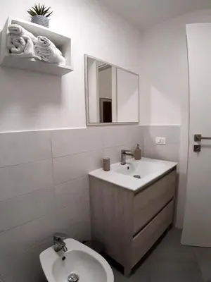 a bathroom with a sink and a toilet and a mirror at Casina al 32 in Palermo