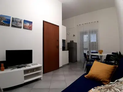 a living room with a couch and a television on a table at Casina al 32 in Palermo