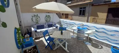 a balcony with an umbrella and a table and chairs at Casetta Colorata in Bagheria