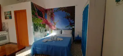a bedroom with a blue bed with towels on it at Casetta Colorata in Bagheria