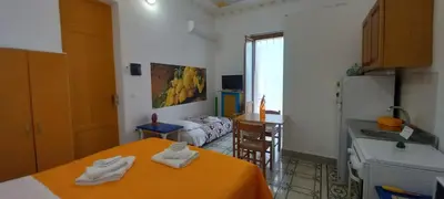 a small room with a kitchen and a bed and a sink at Casetta Colorata in Bagheria