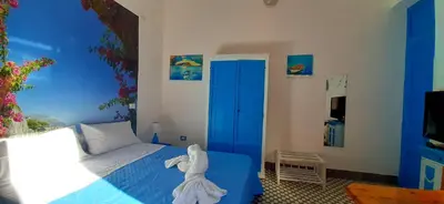 a bedroom with a blue bed and a blue door at Casetta Colorata in Bagheria