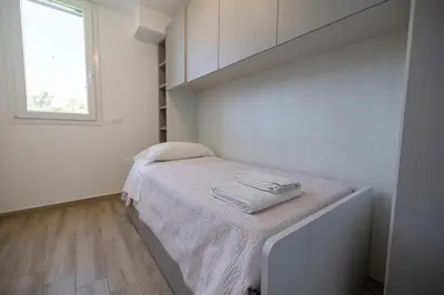 a small bedroom with a bed in a room with a window at Villa Giada - Private pool in Campofelice di Roccella