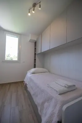 a white bedroom with a bed and a window at Villa Giada - Private pool in Campofelice di Roccella