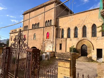 an old brick building with a gate in front of it at Casa Khalesia in Palermo