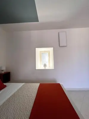 a white room with a bed and a window at Casa Khalesia in Palermo