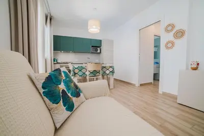 a living room with a couch and a kitchen at Villa Capri - Private pool in Campofelice di Roccella