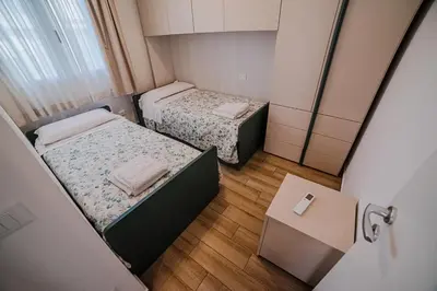 two beds in a small room with a table at Villa Capri - Private pool in Campofelice di Roccella