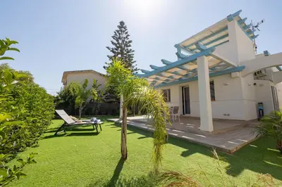 a garden with a bench and a pergola at Villa Amalfi in Campofelice di Roccella