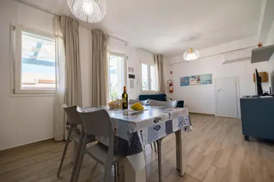 a kitchen and living room with a table and chairs at Villa Amalfi in Campofelice di Roccella
