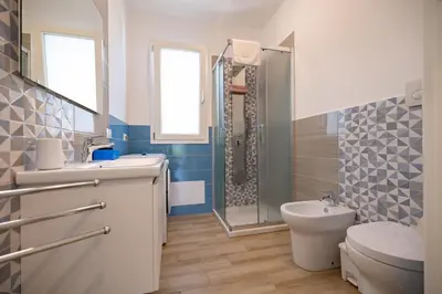 a bathroom with a toilet and a sink and a shower at Villa Amalfi in Campofelice di Roccella
