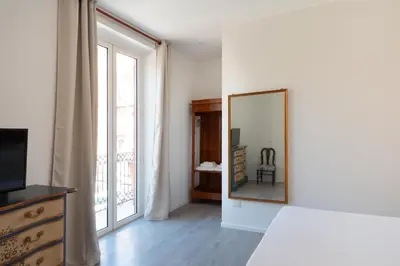 a room with a mirror and a dresser and a window at Dimora Florio in Palermo