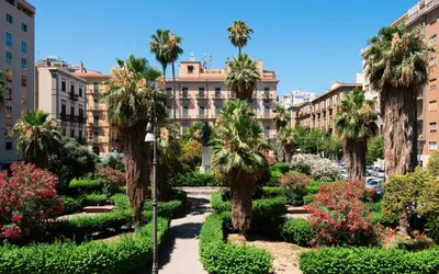 a view of a park with palm trees and buildings at Dimora Florio in Palermo