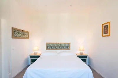 a bedroom with a white bed and two lamps at Dimora Florio in Palermo