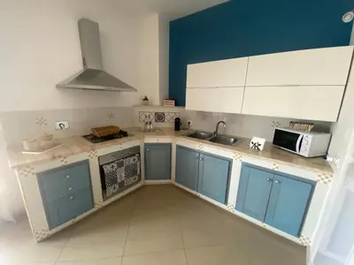 a kitchen with blue cabinets and a sink and a microwave at Casa Ciccio in Cinisi