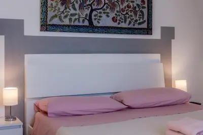 a bedroom with a bed with a painting above it at La mia deliziosa Casetta di giù in Termini Imerese