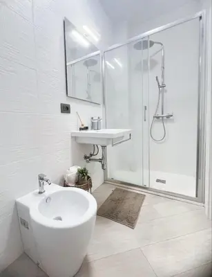 a white bathroom with a sink and a shower at Casa Marinaro in Castellammare del Golfo