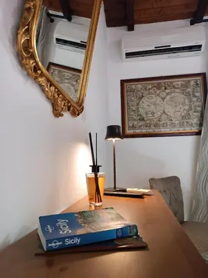 a book on a table with a mirror and a lamp at Duplex House in Palermo