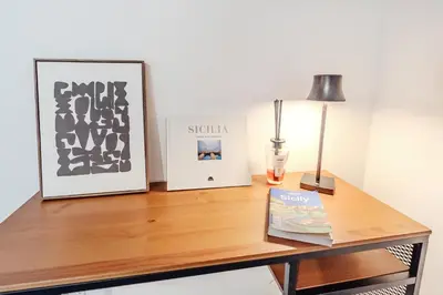 a table with two pictures and a lamp on it at Duplex House in Palermo