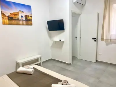 a bedroom with a bed and a tv on the wall at HOLIDAY HOUSE ORLANDO in Palermo
