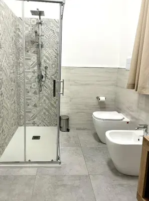 a bathroom with a shower and a toilet and a sink at HOLIDAY HOUSE ORLANDO in Palermo