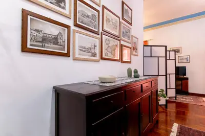 a room with a wooden cabinet and pictures on the wall at Stabile 16 Apartment in Palermo