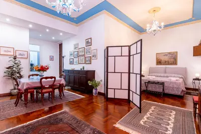 a living room with a table and chairs and a bed at Stabile 16 Apartment in Palermo