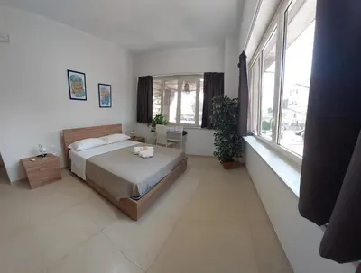 a bedroom with a bed and a large window at Un Passo dal Porto in Palermo
