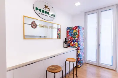 a white kitchen with two stools and a counter at Oliveri Vintage House at Politeama in Palermo