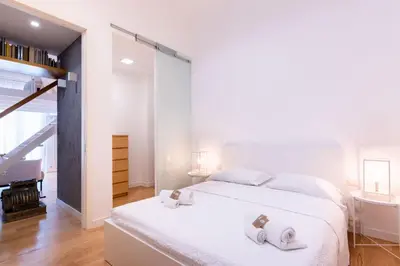 a bedroom with a white bed with two towels on it at Oliveri Vintage House at Politeama in Palermo