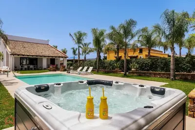 two bottles of beer in a hot tub next to a pool at Posh villa with pool & jacuzzi in Balestrate