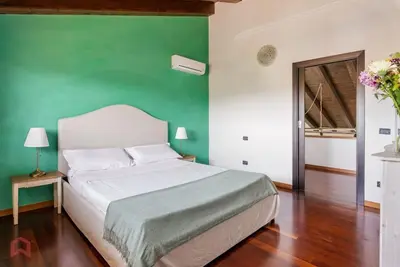 a bedroom with a bed with a green wall at Posh villa with pool & jacuzzi in Balestrate