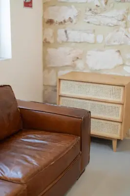a brown leather couch in a living room with a table at Mondello 2C casa vacanze in Palermo