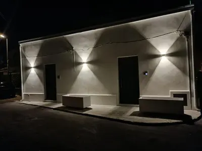 a building with three doors on the side at night at Mondello 2C casa vacanze in Palermo