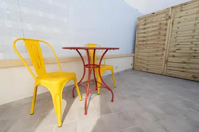 two yellow chairs and a table in a room at Mondello 2C casa vacanze in Palermo